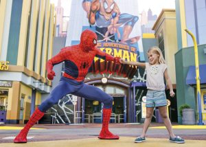 Child fist-bumping Spider-Man near The Amazing Adventures of Spider-Man attraction at Universal Orlando Resort