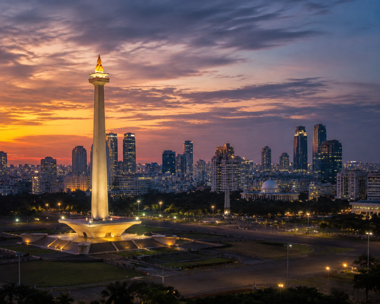 National Monument Monas tower in Jakarta Indonesia with modern city skyline and blue sky, top attraction for Jakarta travel guide visitors