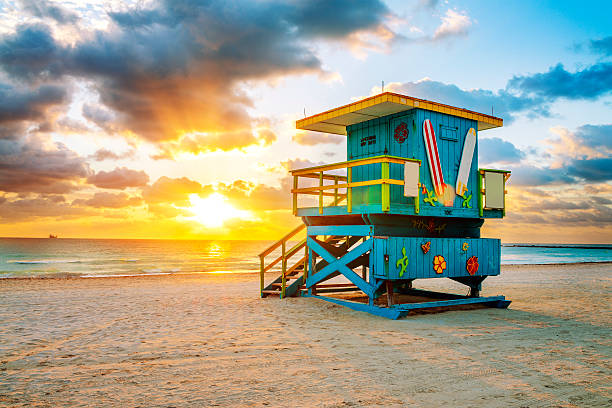 Colorful Art Deco lifeguard tower on South Beach, Miami, with turquoise ocean and pastel buildings in the background