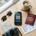 Smartphone showing eSIM QR code setup surrounded by passport and travel items for international travel